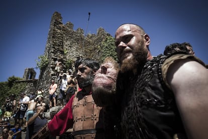 Habitantes de Catoira disfrazados de vikingos durante el pasacalles temático de la Romería Vikinga. Tras los intérpretes, los espectadores realizan fotografías.