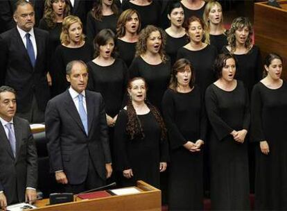 Francisco Camps canta el himno interpretado por el Cor de la Generalitat en el hemiciclo de las Cortes, ayer, tras la toma de posesión.