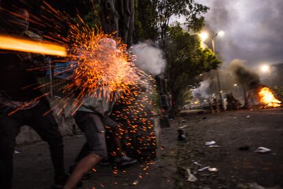 Los manifestantes de la fotografía anterior disparan contra la policía durante el enfrentamiento.