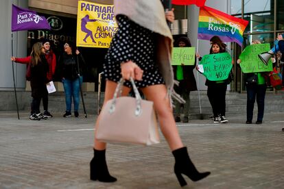 Una mujer pasa frente a una protesta de 'Las Kellys' en Barcelona.