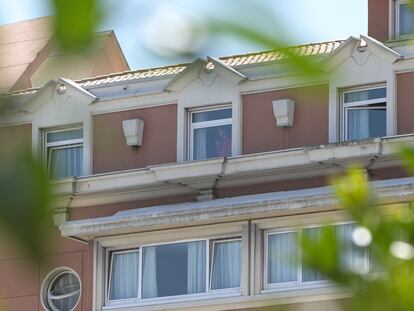 Una persona mira por una ventana del hotel NH Finisterre de A Coruña donde los jugadores del CF Fuenlabrada permanecen confinados en él tras haber dado positivo en coronavirus varios de sus miembros.