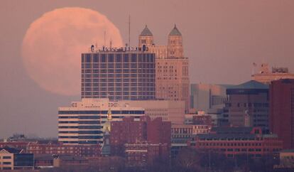 Una luna llena se eleva sobre el horizonte de Kansas City, al atardecer.