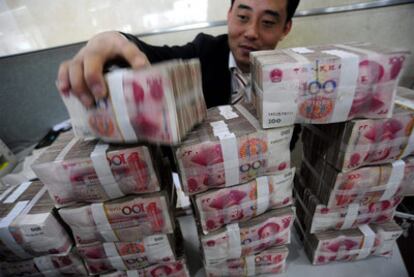 Un empleado de un banco en Hefei (centro de China) manipula paquetes de yuanes.
