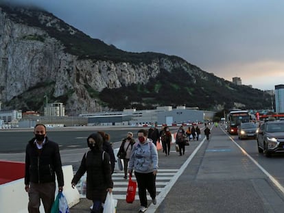 Peatones y vehículos cruzan la pista del aeropuerto de Gibraltar camino de la Verja para pasar a España.