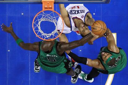 Evan Turner pelea por el balón con los jugadores de Boston Kevin Garnett y Paul Pierce.