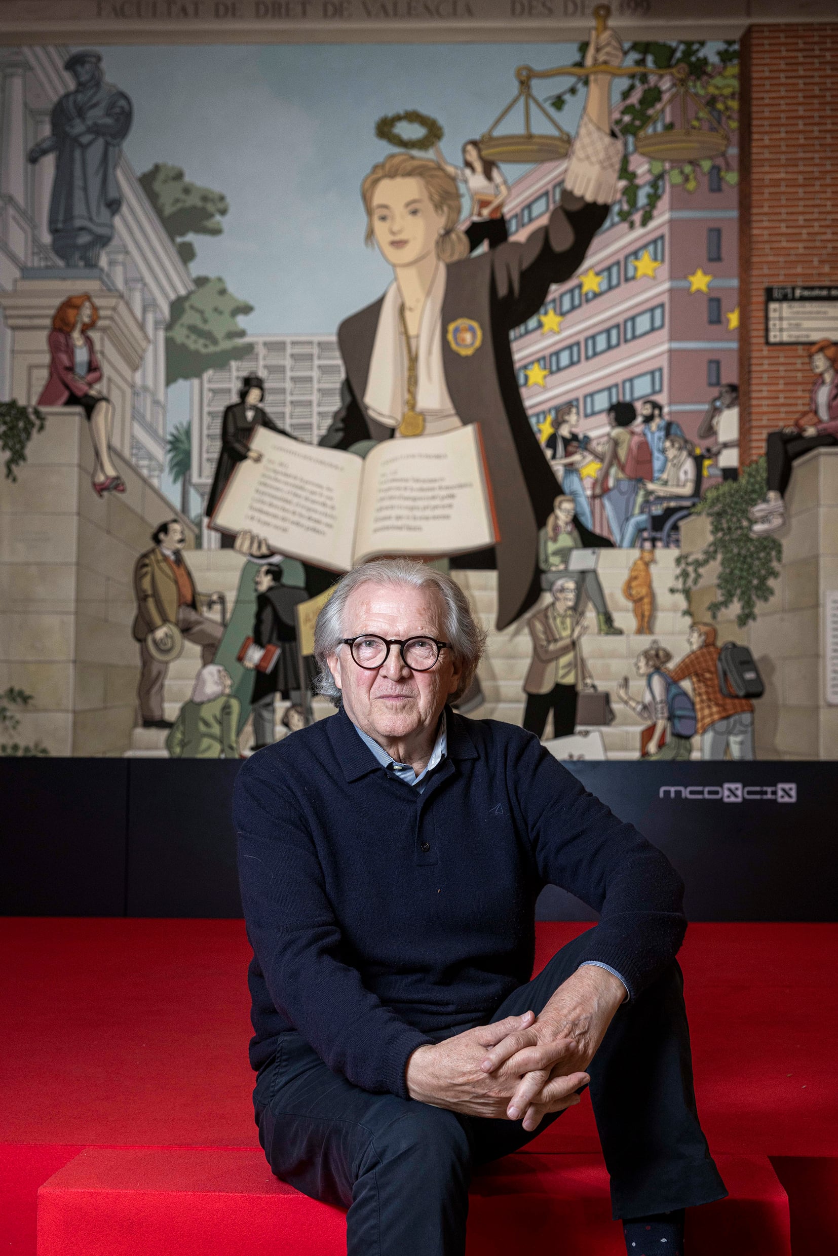 Joan Romero, ante el mural de Paco Roca y Martín Forés que simboliza la justicia imparcial pero sin venda que preside el vestíbulo de la facultad de Derecho.