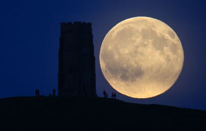 Uma imagem das ruínas da igreja de São Miguel sobre uma colina no povoado de Glastonbury (Reino Unido), com uma lua gigante ao fundo.