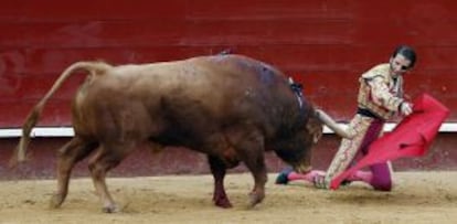 El diestro Juan José Padilla da un pase de rodillas a su primer astado en la quinta corrida de la Feria de Fallas.