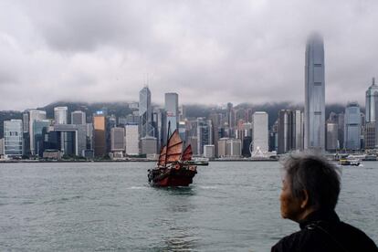 Una señora mayor mira como un barco tradicional zarpa del puerto de Victoria, en Hong-Kong (China).