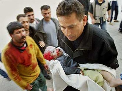 Un palestino, con el cuerpo de Amir Ayyad, el niño de dos años muerto ayer de un disparo en la cabeza en Gaza.