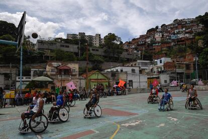 Un grupo de personas en silla de ruedas juegan baloncesto en el barrio de Artigas, en Caracas (Venezuela).