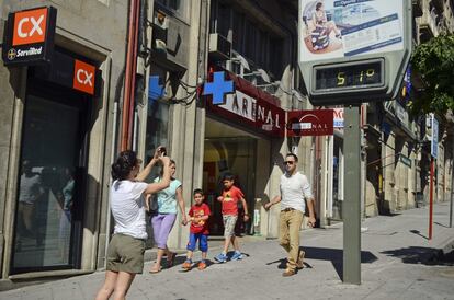 Una mujer fotografía un termómetro, en una calle del centro de Ourense, que marca 51 grados. La Dirección General de Protección Civil y Emergencias del Ministerio del Interior ha alertado de una ola de calor en diversas zonas del país, entre ellas Galicia, para el fin de semana y recomienda extremar las precauciones. 