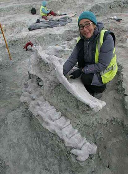 La paleontóloga Fátima Marcos, junto a restos de un dinosaurio hallados en la excavación cerca de Fuentes, Cuenca.