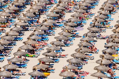 Tourists take in the sun at Magaluf beach in Mallorca.