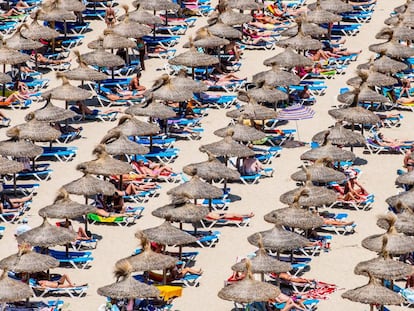 Tourists take in the sun at Magaluf beach in Mallorca.