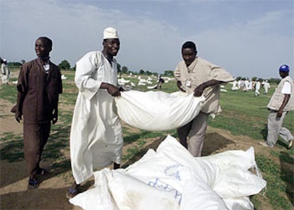 Trabajadores sudaneses acarrean sacos del Programa Mundial de Alimentos en Darfur.