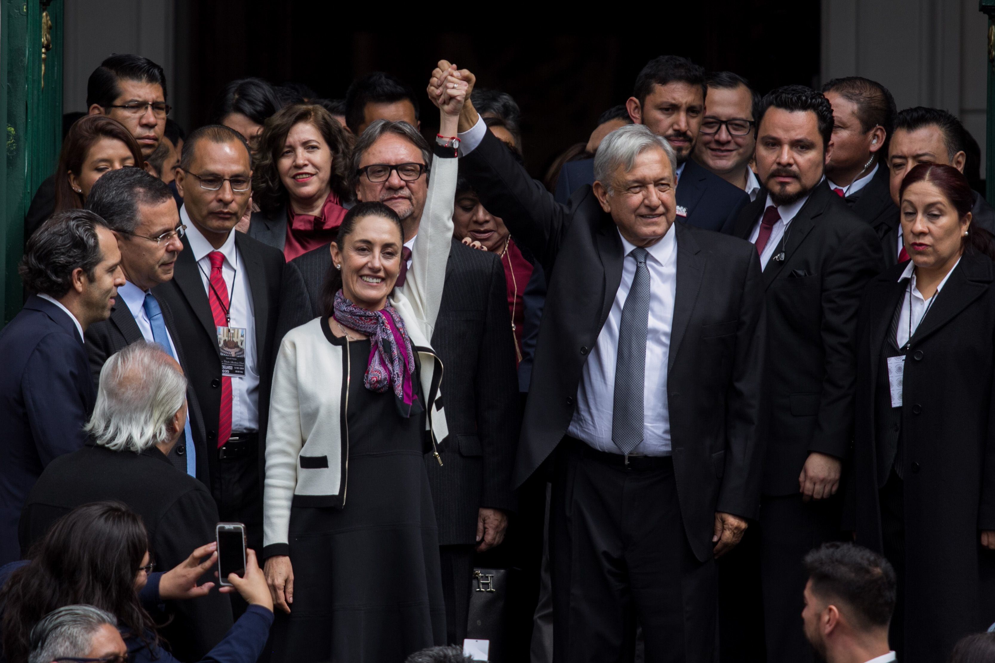 López Obrador levanta el brazo de Sheinbaum durante su toma de protesta como jefa de Gobierno de Ciudad de México, en 2018.