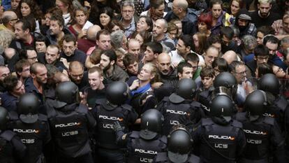 Agentes antidisturbios de la Policía Nacional forman un cordón de seguridad en los alrededores del colegio Ramón Llull de Barcelona.