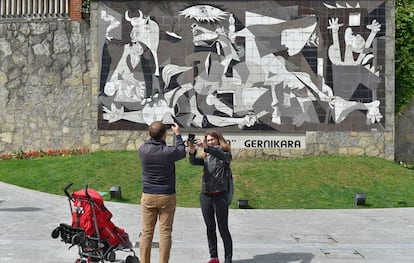 Una pareja toma una foto de una réplica del 'Guernica' de Picasso.
