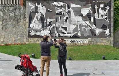 Una pareja toma una foto de una réplica del 'Guernica' de Picasso.