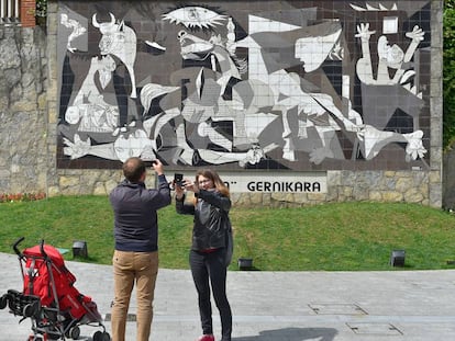 Una pareja toma una foto de una réplica del 'Guernica' de Picasso.