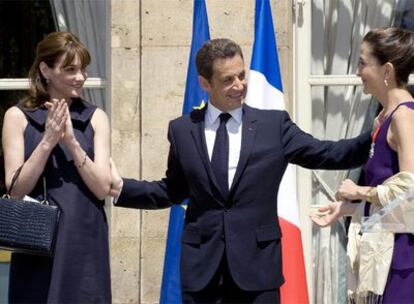 Sarkozy, entre Carla Bruni (izquierda) e Ingrid Betancourt ayer en la fiesta del 14 de julio en el Elíseo.