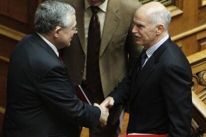 Yorgos Papandreu (a la derecha) saluda a Lukas Papademos, en el Parlamento griego.