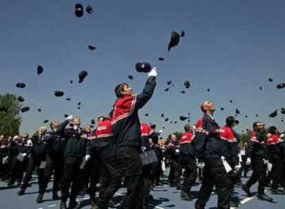 Los nuevos policías municipales lanzan sus gorras al aire durante el acto de entrega de despachos.