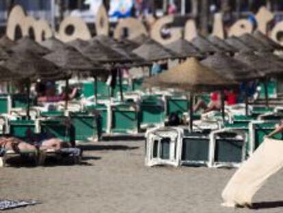 Una mujer disfruta del buen tiempo en la playa de la Malagueta, en M&aacute;laga.