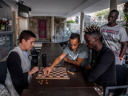 Unn Tove Saetran juega una partida de damas con Sulaiman, un joven de Sierra Leona realojado en el hotel Puerto Calma.