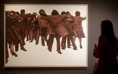 Una persona observa 'El Abrazo', de Genovés.