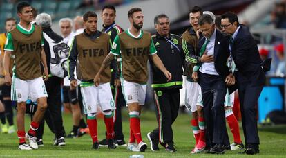 Juan Carlos Osorio (d) es detenido por Lozano y su cuerpo técnico al final del partido