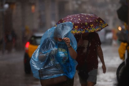 Personas se protegen de la lluvia en el centro de Barcelona, en septiembre de este año.