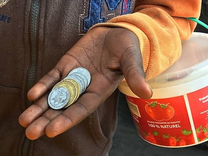 Un niño talibés mendigando a los conductores de vehículos en Dakar.