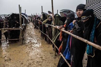 Personas refugiadas rohinyá hacen cola durante horas bajo la lluvia esperando la llegada de ayuda humanitaria.