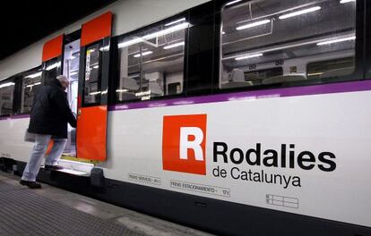 Un pasajero aborda un tren en la estaci&oacute;n de Sants.