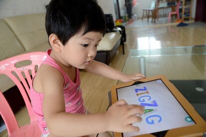 Jiang Siqi es una adicta al iPad, pero sus padres aprovechan la coyuntura para que utilice la tableta como instrumento de aprendizaje. El juego de la fotografía, por ejemplo, le ayuda a familiarizarse con el alfabeto latino.