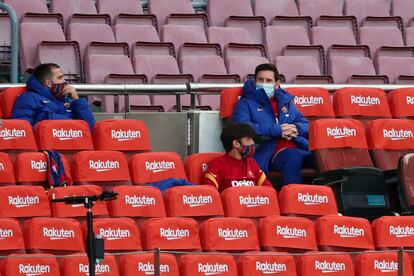 Lionel Messi (a la derecha), en las gradas del Camp Nou.