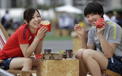 Dos olímpicas japonesas comen del McDonald's en la Villa Olímpica