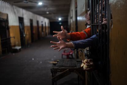 Los presos extienden la mano desde sus celdas para pedir pan a la hora del almuerzo en la prisión Juan de la Vega en Emboscada, Paraguay, el 12 de julio de 2024. 