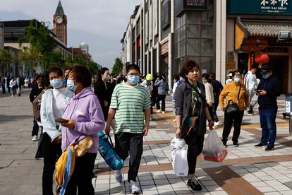 Personas caminando en una calle comercial de Pekín el pasado sábado.