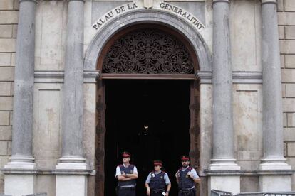 La façana principal del Palau de la Generalitat, a Barcelona En la imatge, tres 'mossos' estan dempeus a la porta d'accés a l'edifici.