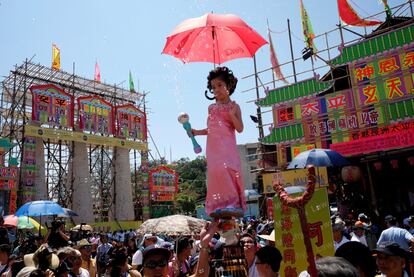 Una participante del festival sobresale entre la multitud con el apoyo de una elaborada plataforma de varillas de metal ocultas en Hong Kong (China). 