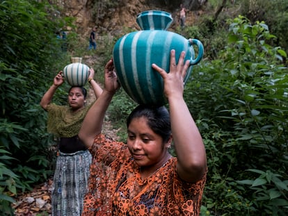 Mujeres guatemaltecas transportando agua desde el río en Chiquisis, San Pedro Carcha (Guatemala).