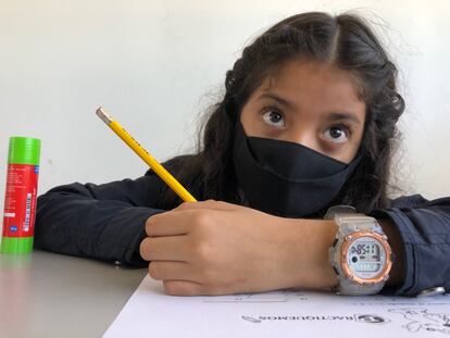 La alumna de tercer grado Weedney Oporta hace deberes con la mascarilla puesta en el colegio La Carpio de San José de Costa Rica. Pincha en la imagen para ver la fotogalería completa.