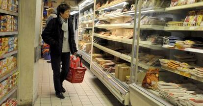 Una clienta observa las estanterías de un supermercado