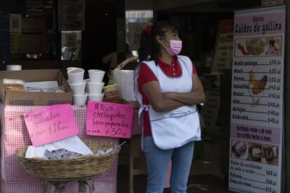 Una mujer espera este sábado clientes en la entrada de su negocio cerca de la estación de metro Chapultepec, en Ciudad de México.