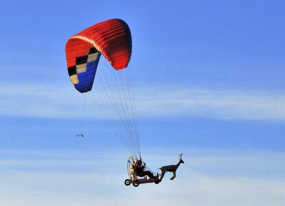 Un hombre disfrazado de Papá Noel viaja sobre un trineo en un parapente con motor en Blagoevgrad (Bulgaria).