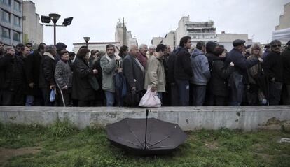 People wait in line to receive food from Athens City Hall.