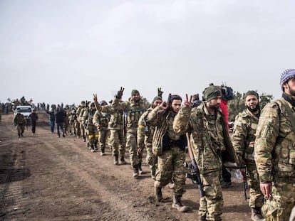 Soldados de la oposición a Bachar el Asad caminan frente a tropas turcas cerca de Hassa el 22 de enero de 2018, para combatir a los kurdos de Siria.